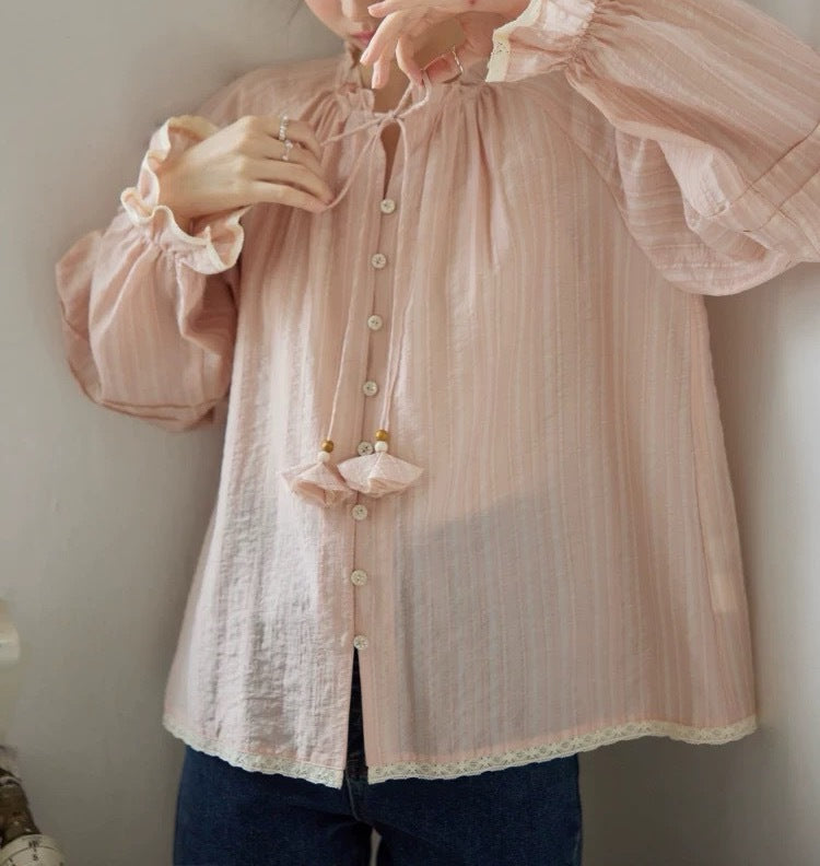 Blusa rosa con cuello de volantes y lazada trasera