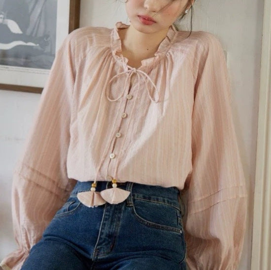 Blusa rosa con cuello de volantes y lazada trasera