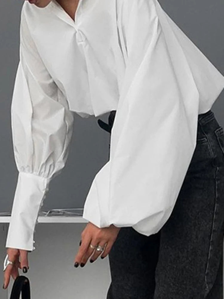 Blusa blanca elegante con volantes y manga larga