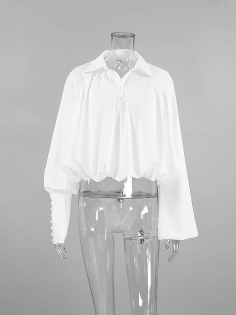 Blusa blanca elegante con volantes y manga larga
