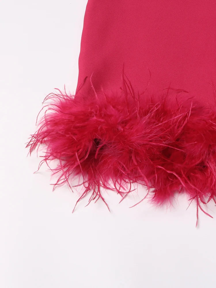 Vestido entallado elegante con detalle de plumas