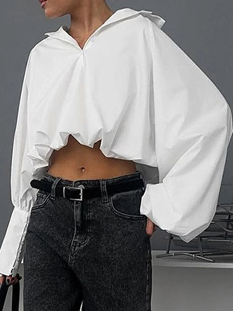 Blusa blanca elegante con volantes y manga larga