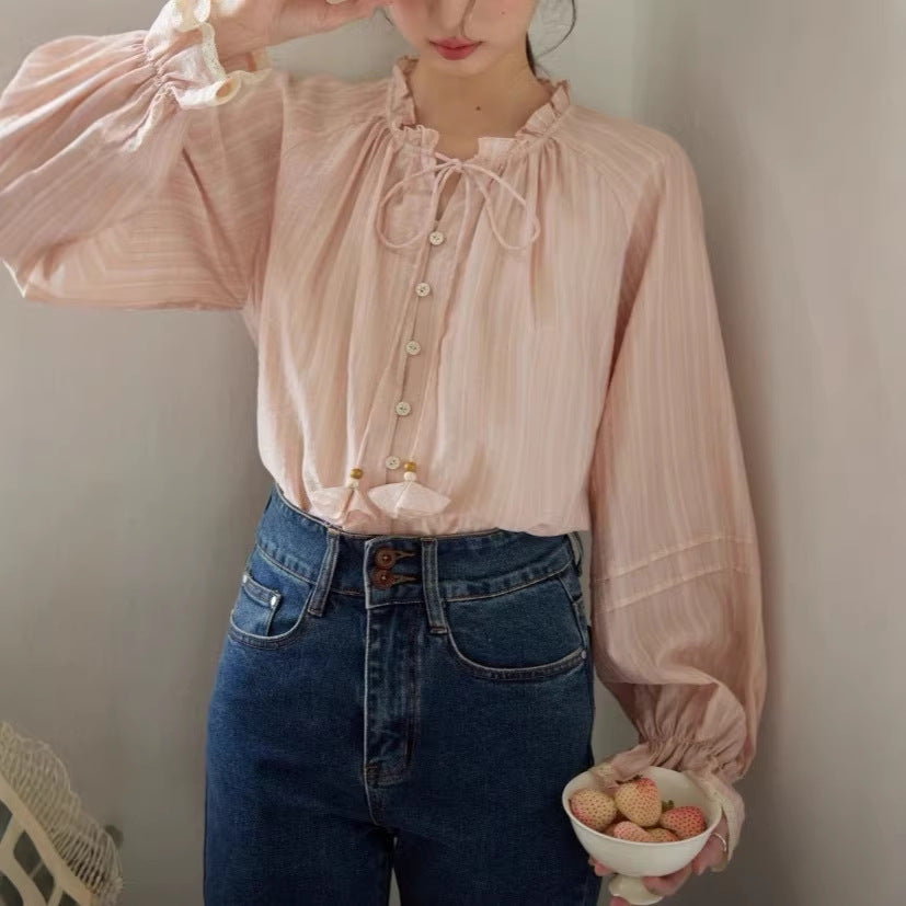 Blusa rosa con cuello de volantes y lazada trasera