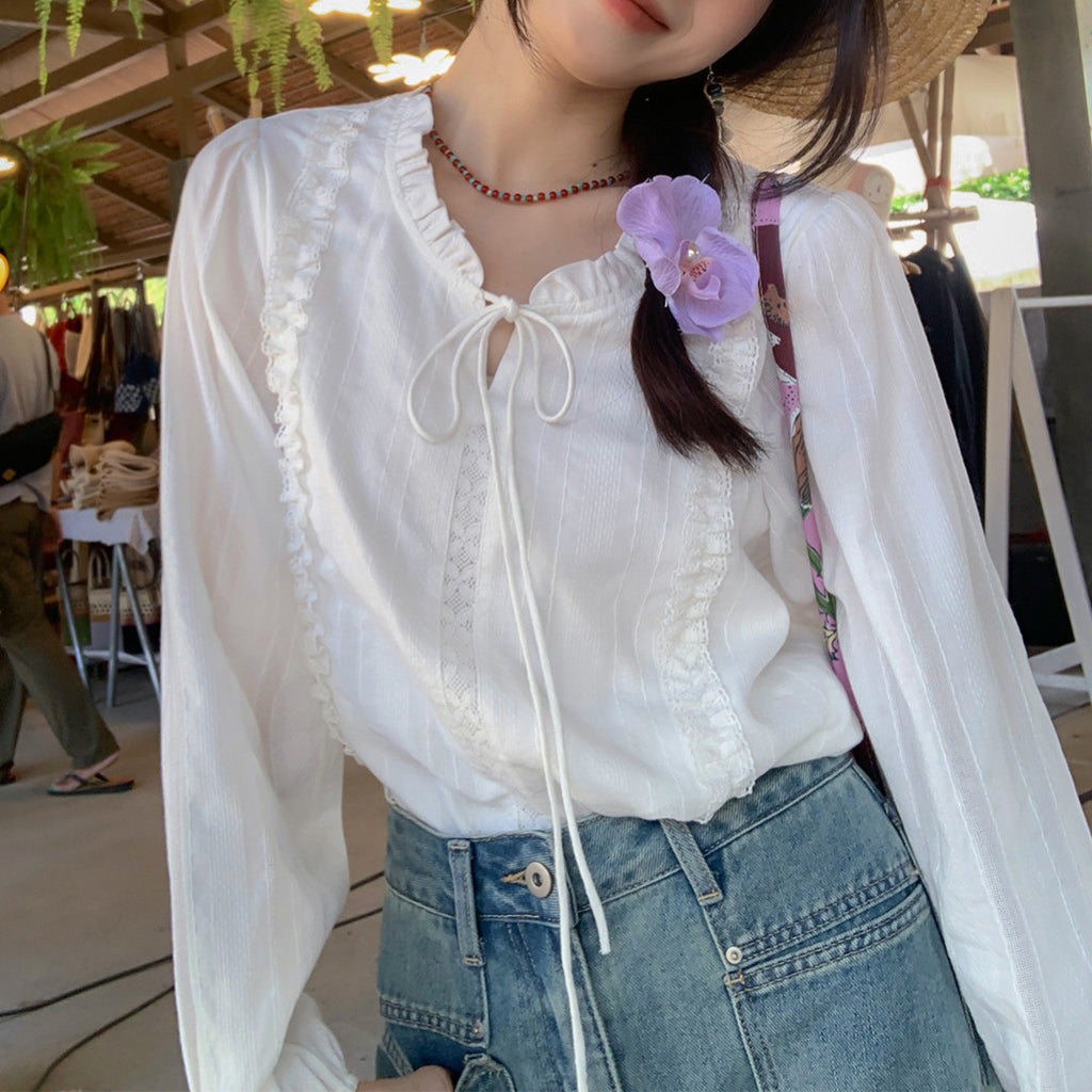 Blusa blanca con cuello de volantes y lazada