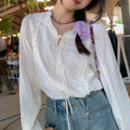 Blusa blanca con cuello de volantes y lazada